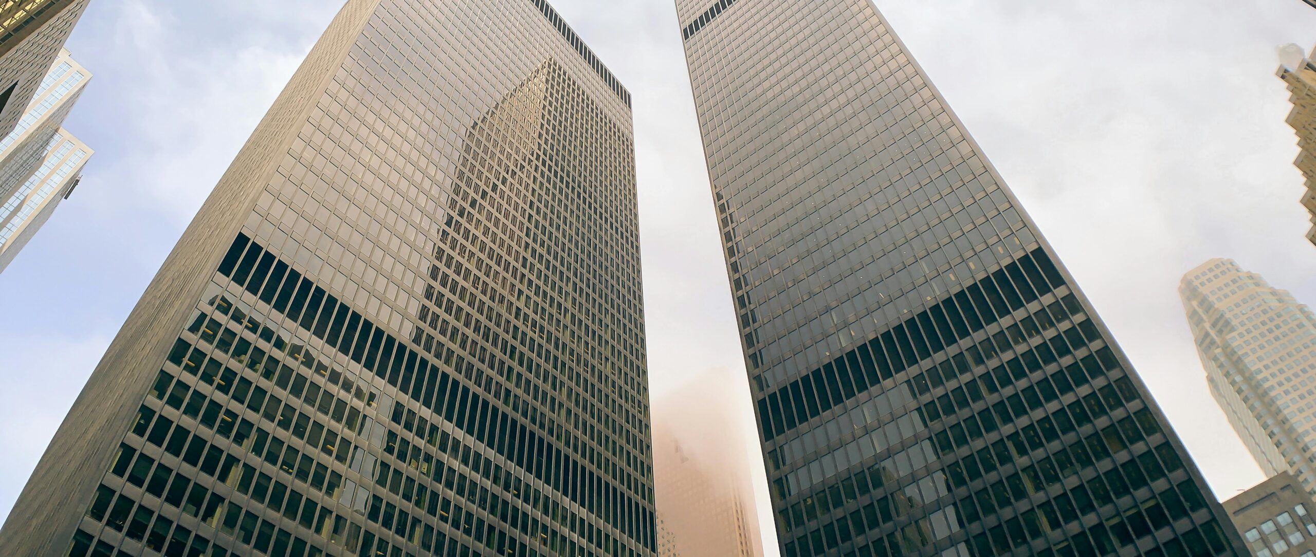 Toronto skyscrapers against a cloudy sky, showcasing urban architecture.